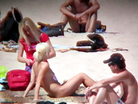 The cute blonde amateur is on this pure nudism video stretching the great natural body on the golden sand of the beach